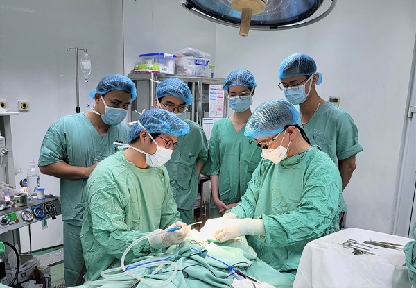 (图片)裴勇灿教授（右）在越南当地为唇腭裂儿童患者进行手术时，正在向当地医疗人员传授手术方法。